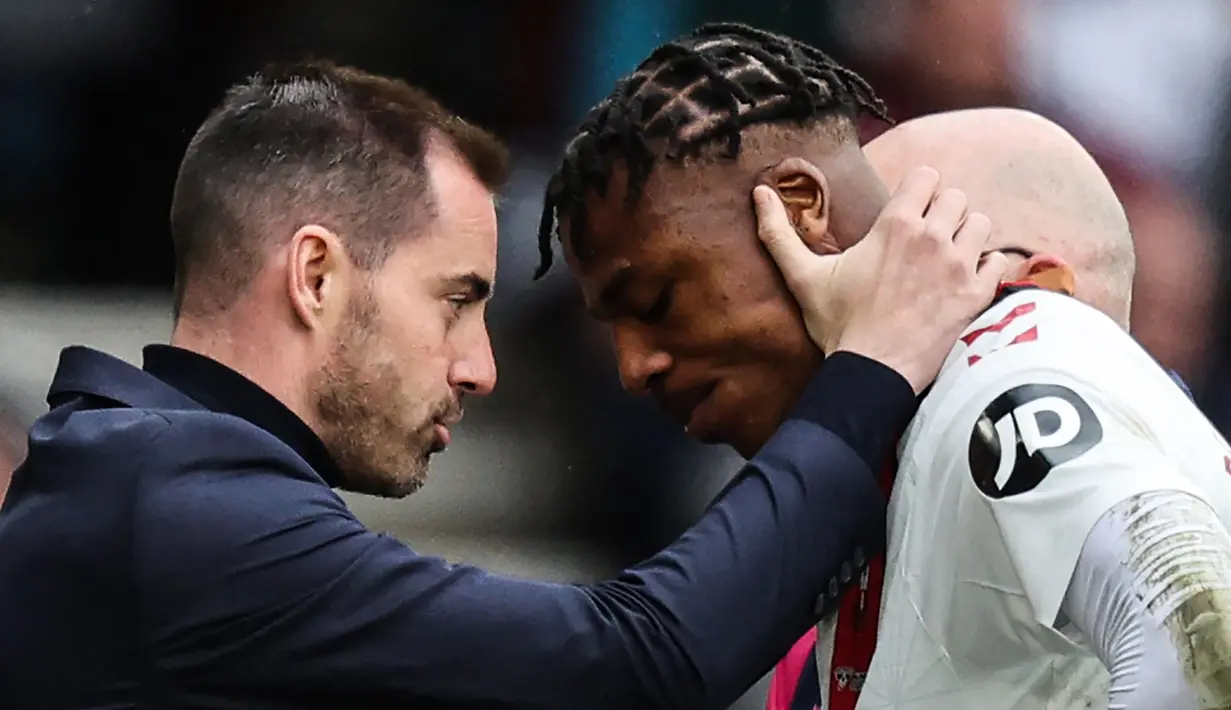 Bek Southampton, Armel Bella-Kotchap (kanan) dihibur pelatih Ruben Selles setelah ditarik keluar akibat cedera saat menghadapi Tottenham Hotspur pada laga Liga Inggris 2022/2023 di St Mary's Stadium, Southampton (18/3/2023). Baru membela Southampton pada awal musim 2022/2023, Armel Bella-Kotchap yang berpaspor Jerman mempunyai potensi menjadi bek hebat. Saat ini ia tengah diincar Eintracht Frankfut dan Liverpool. (AFP/Adrian Dennis)