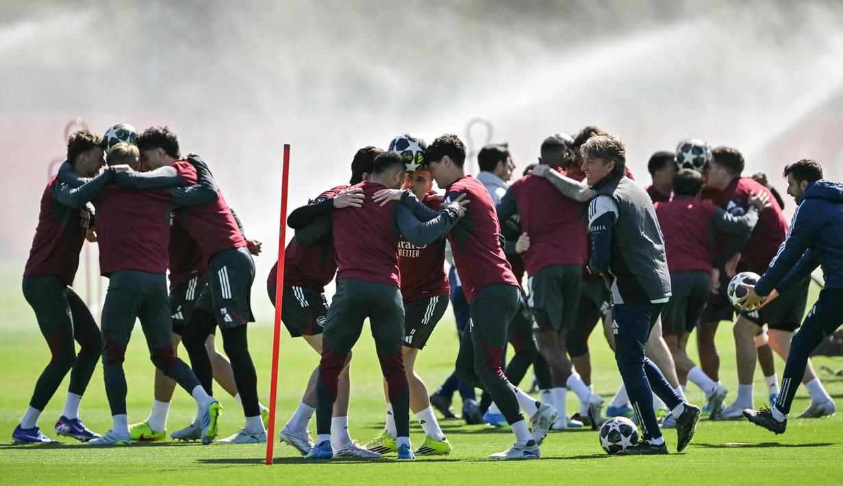 Dilansir dari The Sun, Skuad The Gunners terlihat membentuk lingkaran-lingkaran berisikan empat orang. (AFP/Glyn Kirk)