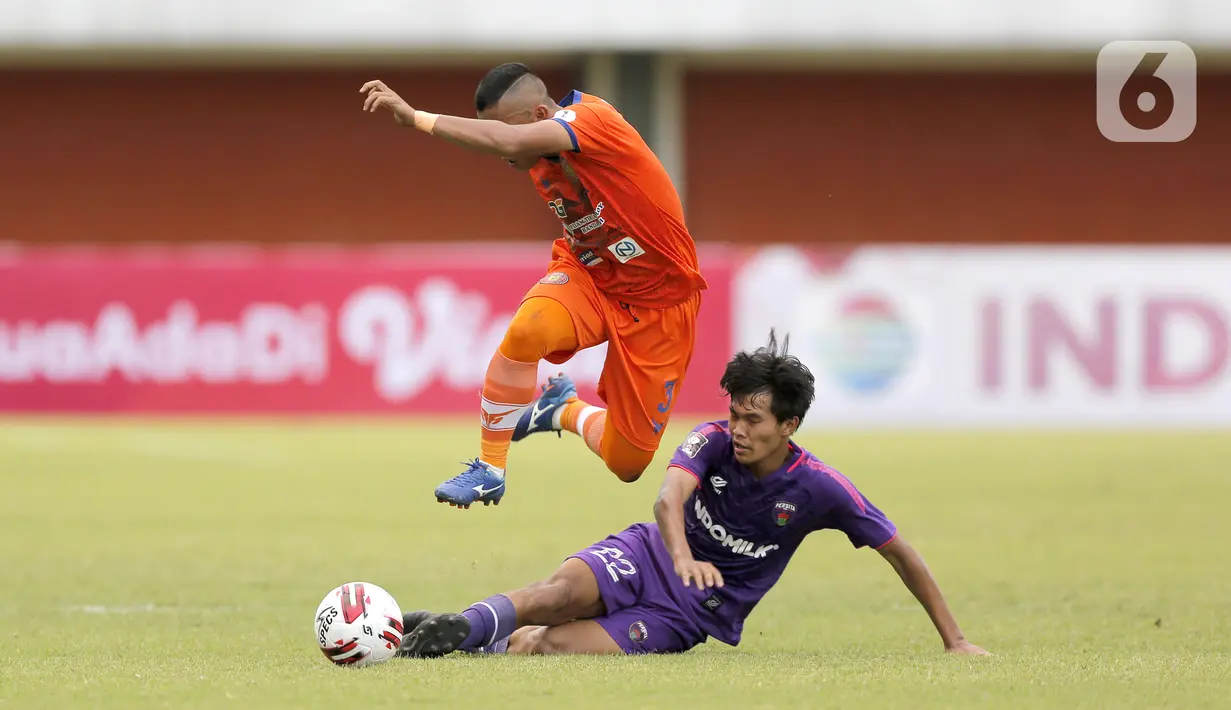 Pemain Persiraja Banda Aceh Eriyanto (kiri) menghindari sapuan kaki pemain Persita Tangerang Rifky Dwi Septiawan dalam pertandingan babak penyisihan Piala Menpora 2021 di Stadion Maguwoharjo, Sleman, Rabu (24/3/2021). Persiraja menang 3-1. (Bola.com/Arief Bagus)