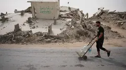UNICEF mencatat 90 persen penduduk Gaza tidak memiliki akses aman terhadap air minum, sementara 96 persen air tanah telah tercemar dan tidak layak digunakan. Tampak dalam foto, seorang pria Palestina membawa wadah air di Kota Gaza, Selasa 12 Mei 2026. (AP Photo/Abdel Kareem Hana)