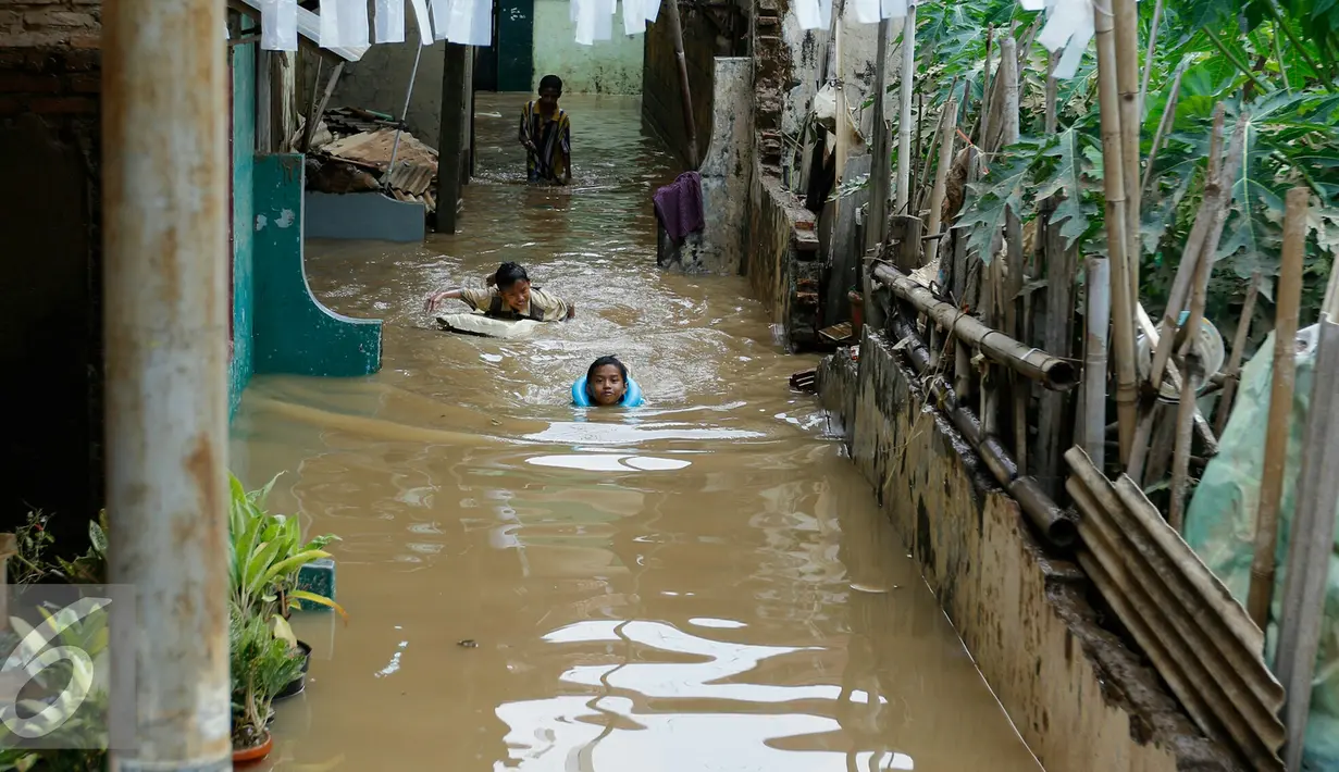 Anak-anak gang H. Maliki, Cawang memanfaatkan banjir untuk berenang, Jakarta, Senin (16/11). Pasca datangnya air kiriman dari Bogor, puluhan rumah di pinggir kali Ciliwung terendam banjir dengan ketinggian mencapai 3 meter. (Liputan6.com/Yoppy Renato)