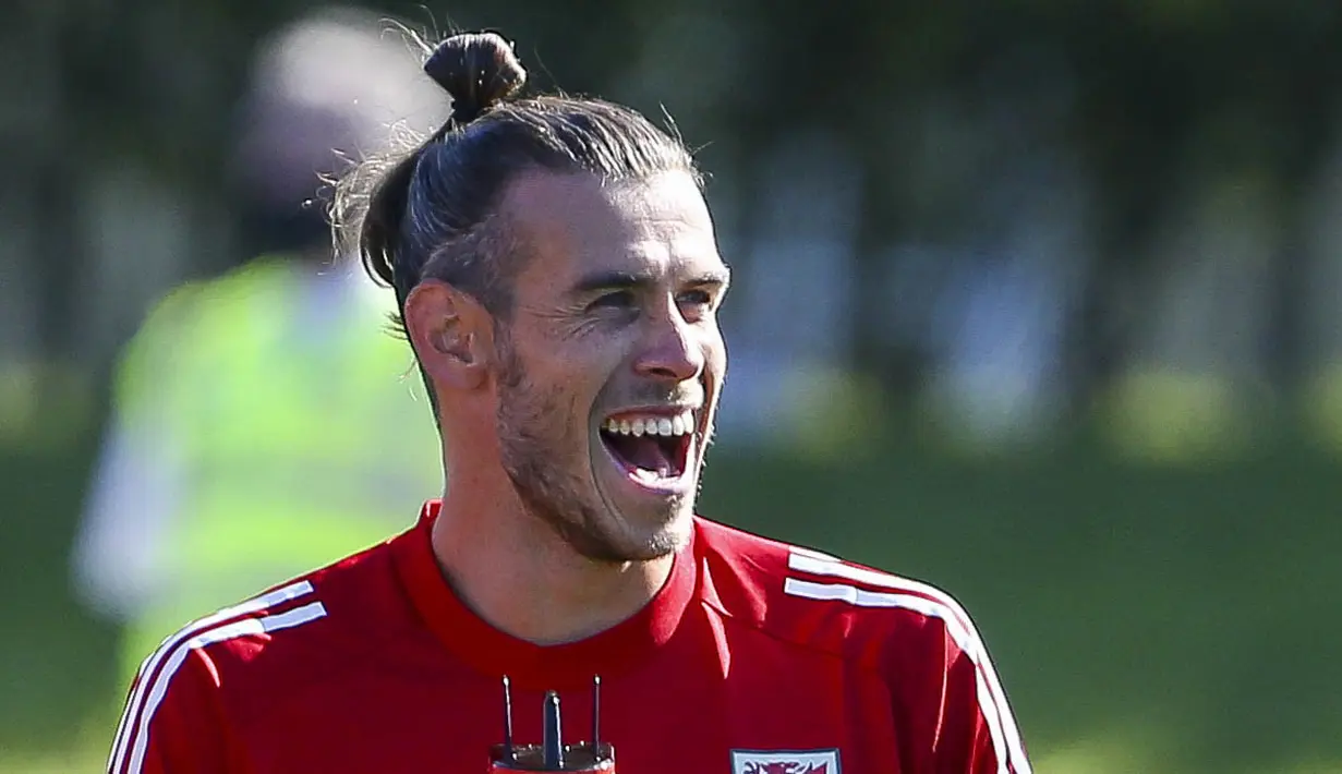 Pemain Timnas Wales, Gareth Bale, tertawa saat mengikuti latihan jelang laga UEFA Nations League di Hensol, South Wales, Senin (31/8/2020). Wales akan berhadapan dengan Finlandia. (AFP/Geoff Caddick)