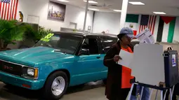 Seorang wanita memberikan suaranya di sebuah showroom mobil, Sam's Auto Sales, yang dijadikan lokasi tempat pemungutan suara (TPS) pemilihan presiden Amerika Serikat (Pilpres AS) di Chicago, Illinois, Selasa (8/11). (REUTERS/Jim Young)