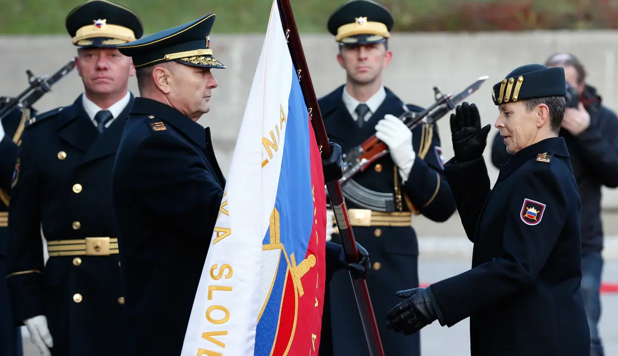 Mayor Jenderal Alenka Ermenc menerima bendera Tentara Slovenia saat upacara serah terima jabatan sebagai Panglima Militer di Ljubljana, Rabu (28/11). Ibu tiga anak itu sebelumnya menjabat sebagai Deputi Kepala Staf Militer. (AP/Darko Bandic)