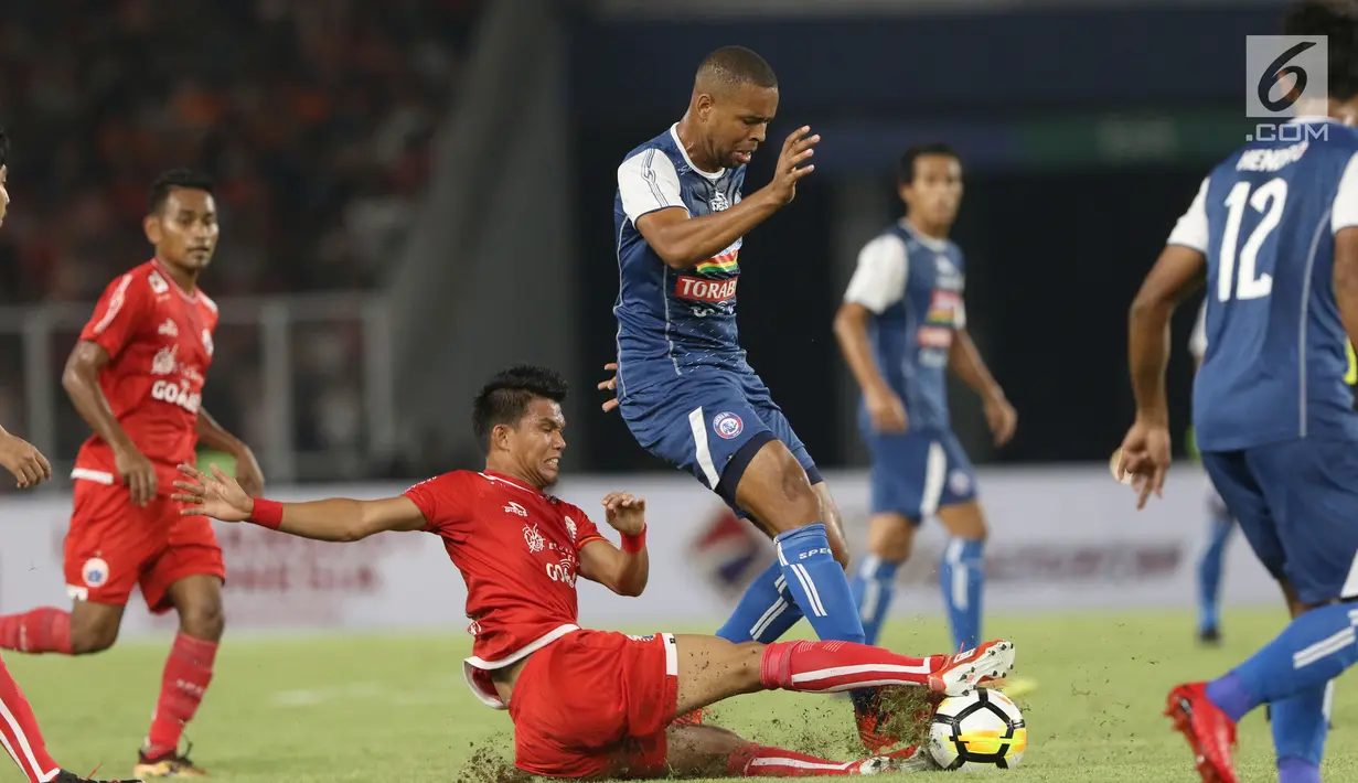 Gelandang Persija, Sandi Sute (bawah) menahan pemain Arema FC, Thiago Furtuoso Dos Santos saat laga lanjutan Go-Jek Liga 1 Indonesia 2018 bersama Bukalapak di Stadion GBK Jakarta, Sabtu (31/3). Persija unggul 3-1. (Liputan6.com/Helmi Fithriansyah)