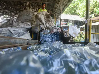Pekerja mengolah sampah botol kemasan menjadi cacahan sebagai bahan biji plastik di Koperasi Pemulung Berdaya atau Recycle Business Unit (RBU) Tangerang Selatan, Tangerang, Banten, Rabu (30/7/2025). (merdeka.com/Arie Basuki)