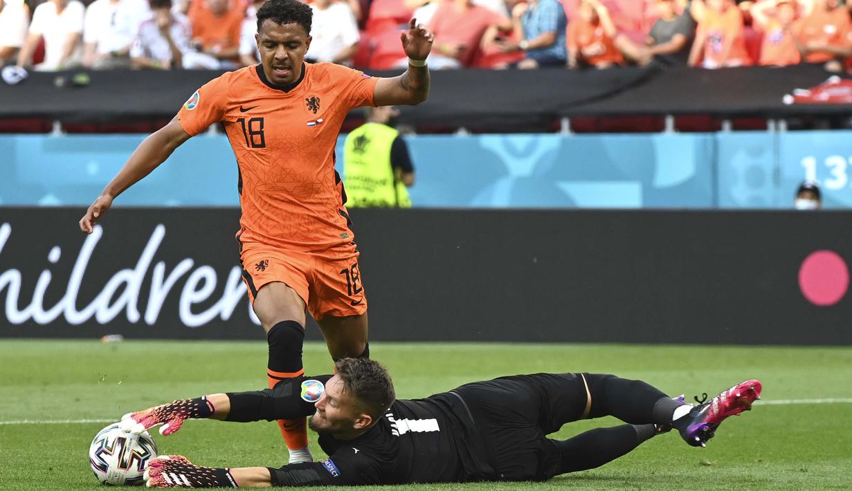 Pemain Timnas Belanda, Donyell Malen (kiri) berebut bola dengan kiper Republik Ceska Tomas Vaclik pada pertandingan babak 16 besar Piala Eropa 2020 antara Belanda melawan Republik Ceska di Puskas Arena, Hongaria, Minggu, (27/6/2021). (Foto: AP/Pool/Attila Kisbenedek)
