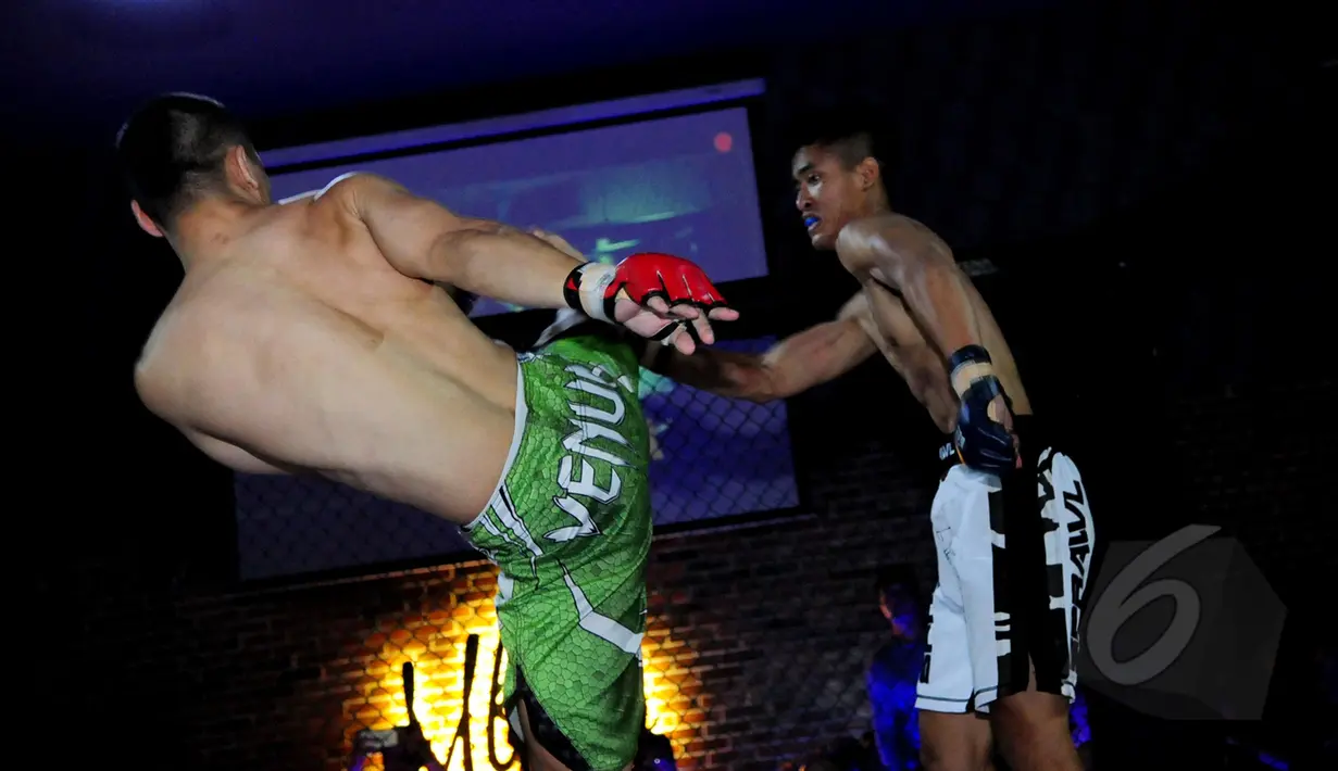 Atlet petarung berusaha menendang lawannya pada ajang XXC Championship 2015 yang dihelat di Embrio Markas Cafe, Jakarta, Minggu (12/04/15). XCC Championship 2015 salah satu olah raga bela diri MMA (Mixed Matrial Arts). (Liputan6.com/Faisal R Syam)