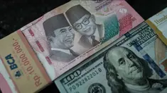 Uang kertas Rp 100.000 diletakkan berdampingan dengan uang dolar Amerika Serikat di salah satu kantor penukaran, Jakarta, Kamis pada 4 Juni 2026. (Yasuyoshi Chiba/AFP)