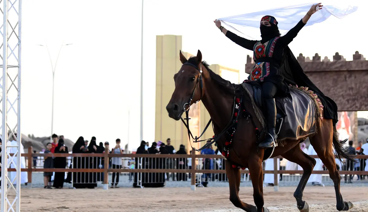 Perempuan Arab menunggangi kuda selama Festival Souk Okaz 2019 di Kota Taif, Arab Saudi, Rabu (7/8/2019). Festival Souq Okaz merupakan ajang untuk berbagi warisan budaya dan sosial. (AMER HILABI/AFP)