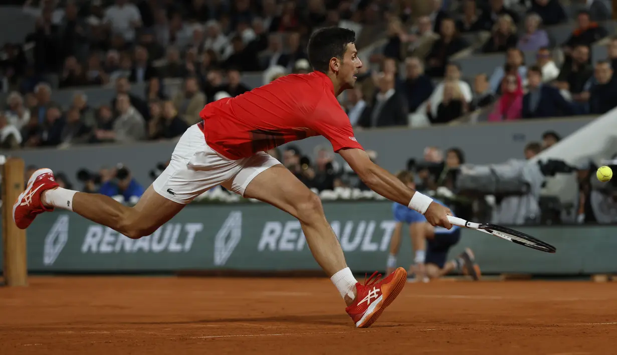 <p>Petenis Serbia, Novak Djokovic berusaha mengembalikan bola pukulan Rafael Nadal dari Spanyol dalam pertandingan perempat final turnamen French Open 2022 di stadion Roland Garros di Paris, Rabu (1/6/2022). Nadal berhasil melaju ke semifinal usai mengalahkan Djokovic dengan skor 6-2, 4-6, 6-2, 7-6(4). (AP Photo/Jean-Francois Badias)</p>