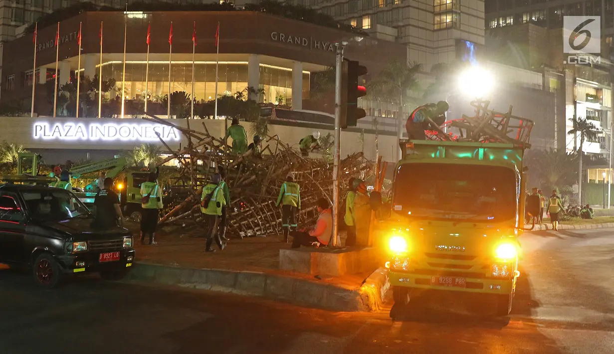 Petugas Dinas Kehutanan DKI Jakarta memuat rangkaian instalasi bambu Getah Getih ke dalam truk di Bundaran Hotel Indonesia (HI), Kamis (18/7/2019) dini hari. Karya seni tersebut rencananya akan diganti dengan taman dan bambu itu akan dibawa ke tempat pembuangan sampah. (Liputan6.com/Herman Zakharia)