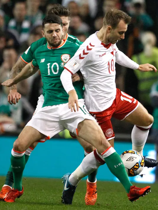 Pemain Denmark, Christian Eriksen dan pemain Republik Irlandia, Robbie Brady berebut bola pada partai kedua play-off zona Eropa di Stadion Aviva, Rabu (15/11). Denmark melaju ke putaran final Piala Dunia 2018 usai menang 5-1. (AP/Peter Morrison)