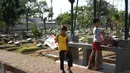 Anak-anak bermain di sekitar Taman Pemakaman Umum (TPU) Karet Bivak, Jakarta, Selasa (10/9/2019). Keterbatasan ruang terbuka hijau memaksa sebagian anak-anak di Ibu Kota bermain tidak pada tempatnya, meskipun dalam kondisi yang tidak layak. (Liputan6.com/Immanuel Antonius)