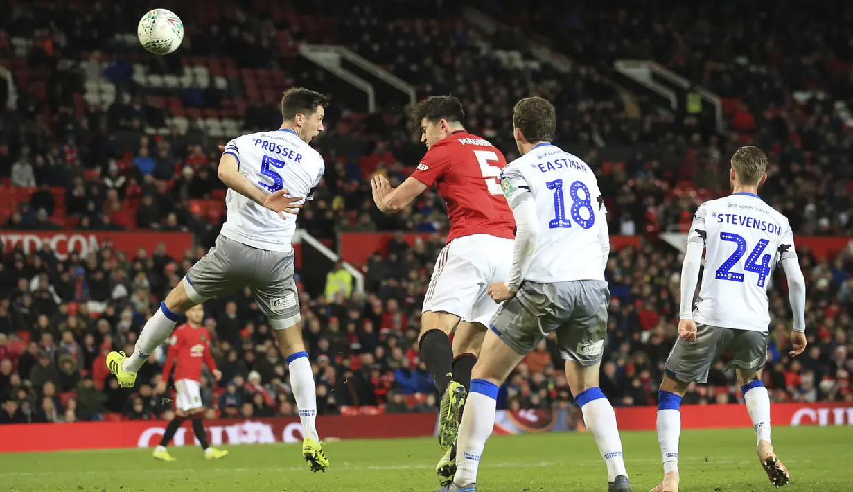 Bek Manchester United, Harry Maguire (kedua kiri) menyundul bola saat bertanding melawan Colchester United pada perempat final Piala Liga Inggris di Old Trafford (18/12/2019). Di semifinal, MU akan bertemu Manchester City. (AP Photo/Jon Super)