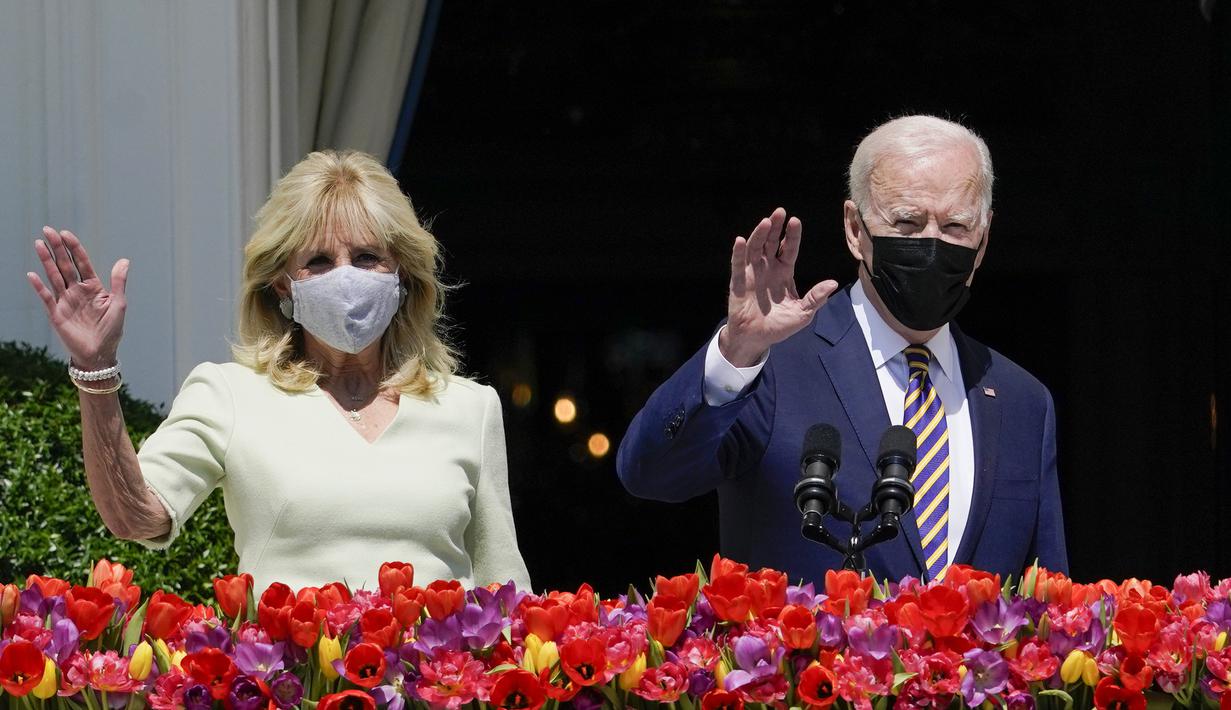 Presiden Joe Biden bersama Ibu Negara Jill Biden melambaikan tangan dari balkon Ruang Biru, Gedung Putih, Washington, Amerika Serikat, Senin (5/4/2021). Gedung Putih kembali meniadakan tradisi Easter Egg Roll menyusul pandemi COVID-19 yang sedang berlangsung. (AP Photo/Evan Vucci)