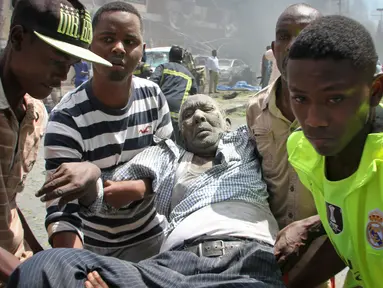 Sejumlah orang membawa pria yang terkena akibat serangan bom mobil di Mogadishu, Somalia, Senin (13/3). Sebuah mobil meledak di dekat Hotel Weheliye dan menewaskan sejumlah orang. (AP Photo / Farah Abdi Warsameh)