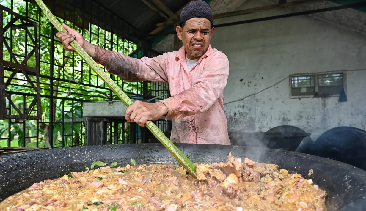 Seorang pria memasak kari tradisional untuk dibagikan saat merayakan Maulid Nabi Muhammad SAW di Krueng Barona Jaya pada 28 September 2023. (Chaideer Mahyuddin/AFP)