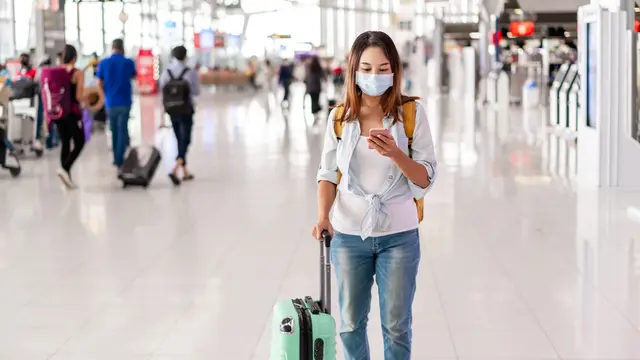 perempuan pakai masker di bandara