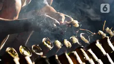 Pekerja melakukan pembakaran lemang bambu di Jalan Kramat Raya, Senen, Jakarta Pusat, Rabu (6/4/2022). Selama Ramadhan, pembuat lemang mampu memproduksi hingga 300 buah dalam sehari, meningkat hingga tiga kali lipat dari hari biasa. (Liputan6.com/Herman Zakharia)