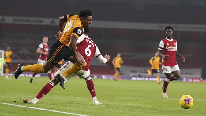 Penyerang Wolverhampton Wanderers, Adama Traore berebut bola dengan bek Arsenal, Gabriel pada pekan kesepuluh Liga Inggris di Emirates Stadium, London, Minggu (29/11/2020). Arsenal takluk 1-2 dari Wolverhampton Wanderers. (John Walton/Pool via AP)