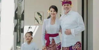 Farah Quinn bersama suaminya, Charles Jost dan Putrinya, Amaira kompak mengenakan pakaian serba putih dan kain khas Bali warna emas keunguan sebagai bawahan saat berada di Bali (@farahquinnofficial)