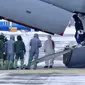 Petugas medis menyambut kedatangan warga yang turun dari pesawat militer di sebuah bandara luar Tyumen, Rusia, Rabu (5/2/2020). Rusia mengevakuasi 144 orang dari Wuhan yang terdiri dari warga Rusia, Belarus, Ukraina, dan Armenia menyusul wabah virus corona. (AP Photo/Maxim Slutsky)