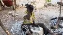 Seorang bocah tampak memecahkan batu di sebuah tambang di Ouagadougou, Burkina Faso, 21 Desember 2015. Pada 12 Juni, Organisasi perburuhan Internasional melakukan aksi menentang mempekerjakan anak dibawah umur. (NABILA EL Hadad / AFP)