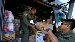 Dari Posko Terpadu Penanggulangan Bencana yang berpusat di Lanud Sultan Iskandar Muda, bantuan dikirim sepanjang hari melalui jalur udara, menjangkau daerah-daerah yang terisolasi akibat cuaca ekstrem dan rusaknya akses. Tampak dalam foto, personel TNI AU memuat pasokan yang akan didistribusikan kepada warga di wilayah terdampak banjir ke dalam helikopter di Pangkalan Udara (Lanud) Sultan Iskandar Muda di Blang Bintang, Aceh Besar pada Kamis 4 Desember 2025. (CHAIDEER MAHYUDDIN/AFP)