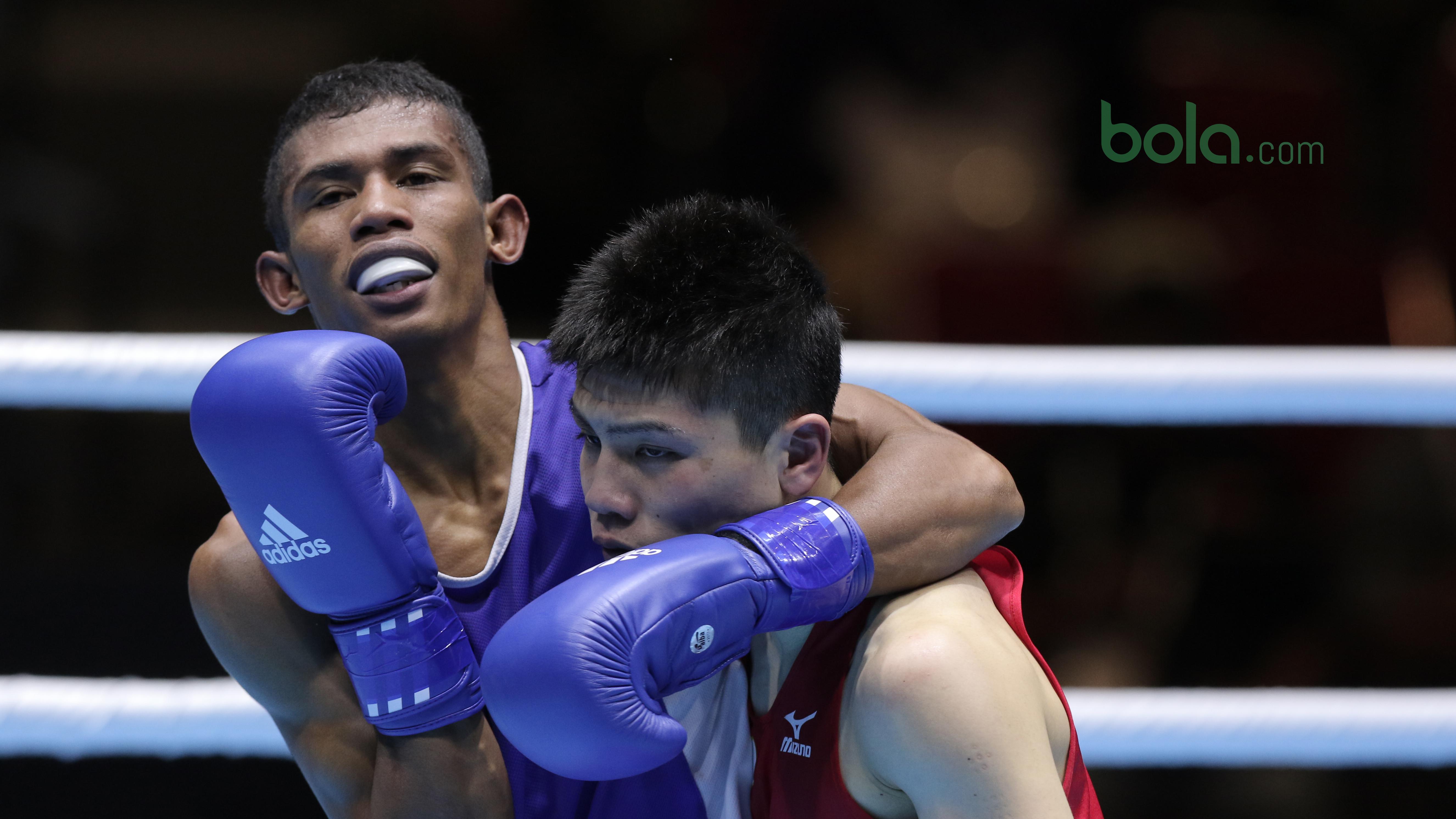 Petinju Indonesia, Mario Blasius Kali (kiri) saat melawan petinju asal Jepang, Tomoya Tsuboi pada semifinal Test Event Asian Games 2018 kelas terbang ringan di Kemayoran, Jakarta (14/2/2018). Mario menang dengan skor 3-2. (Bola.com/Nick Hanoatubun)