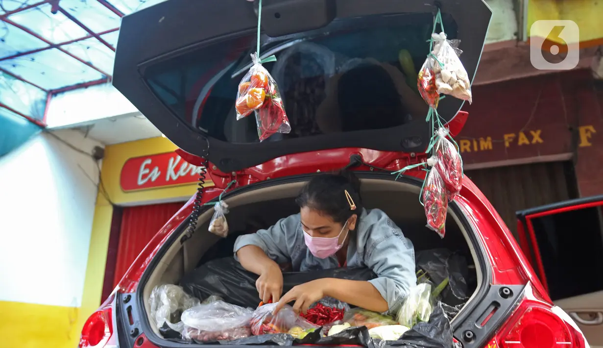 Cynthia (28) mahasiswi perguruan tinggi swasta merapikan dagangannya di Jalan Santosa, Depok, Jawa Barat, Kamis (21/5/2020). Cynthia berjualan berbagai macam sayuran guna memenuhi kebutuhan sehari-hari di tengah pandemi Covid-19. (Liputan6.com/Herman Zakharia)