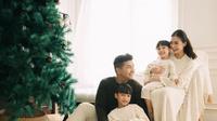 Chelsea Olivia dan Glenn Alinskie bersama kedua anaknya juga telah membagikan foto dengan pohon natal tahun ini. Chelsea tampil mengenakan dress putih polos panjang. [@chelseaoliviaa]