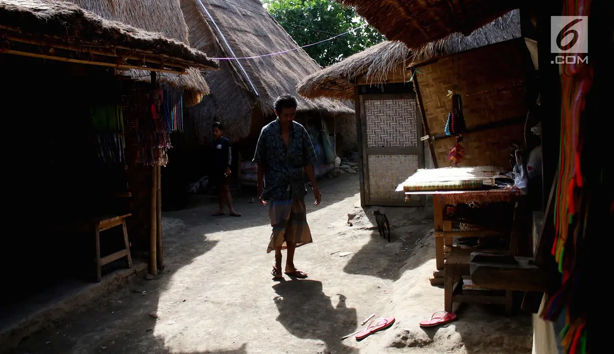 Menyusuri tanah tak beraspal saat memasuki perkampungan berdiri kokoh  rumah adat beratap ilalang. Sepanjang mata memandang nampak para pemilik rumah tengah sibuk menenun kain khas setempat. (Liputan6.com/Angga Yuniar)