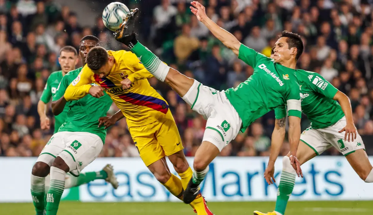Bek Barcelona, Clement Lenglet (kiri) dan berebut bola dengan pemain Real Betis, Aissa Mandi pada lanjutan Liga Spanyol pekan ke-23 di Benito Villamarin, Minggu (9/2/2020). Diwarnai dua kartu merah, Barcelona mememangkan duel menegangkan lawan Real Betis 3-2. (AP/Miguel Morenatti)
