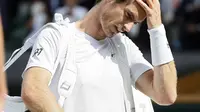 Andy Murray memegang hanya tertunduk saat keluar dari arena usai kalah dari Sam Querrey pada laga tunggal putra Wimbledon Tennis Championships 2017 di London, (12/7/2017). (AP/Kirsty Wigglesworth)