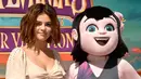 Selena Gomez berpose dengan boneka Mavis saat mempromosikan film terbarunya "Hotel Transylvania 3: Summer Vacation", California (11/4). Film 3D animasi komputer horor-komedi ini diproduksi oleh Sony Pictures Animation. (Matt Winkelmeyer/Getty Images/AFP)