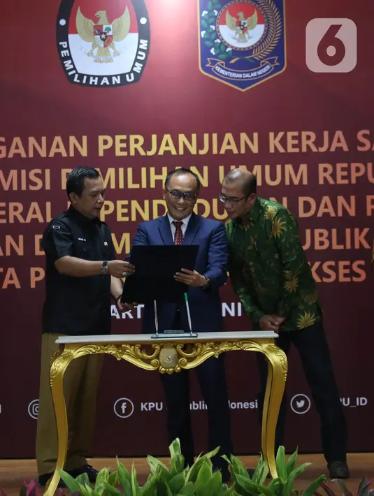 Sekretaris Jenderal KPU RI Bernad Dermawan Sutrisno (kiri), Dirjen Dukcapil Zudan Arif Fakrulloh (tengah), dan Ketua KPU RI Hasyim Asy'ari (kanan) saat penandatanganan perjanjian kerja sama antara Direktur Jenderal Dukcapil Kemendagri dengan Sekretaris Jenderal KPU RI di Gedung KPU, Jakarta, Rabu (29/6/2022). Kerja sama ini mengenai pemanfaatan nomor induk kependudukan, data kependudukan, dan kartu tanda penduduk elektronik dalam pemutakhiran data pemilih. (Liputan6.com/Angga Yuniar)