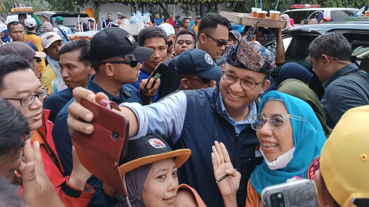Anies Baswedan melayani emak-emak berfoto bersama di Surabaya. (Dian Kurniawan/Liputan6.com)