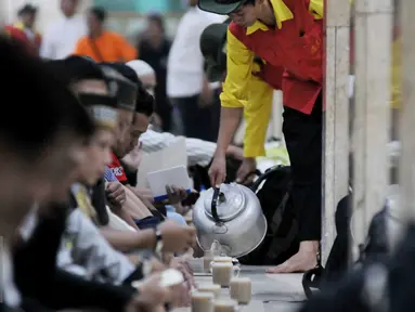 Petugas menuangkan minuman untuk berbuka kepada para jamaah yang hadir di Masjid Istiqlal, Jakarta (22/6/2015). Sekitar 3000 kotak makanan dan minuman dibagikan setiap harinya selama bulan Ramadan. (Liputan6.com/JohanTallo)