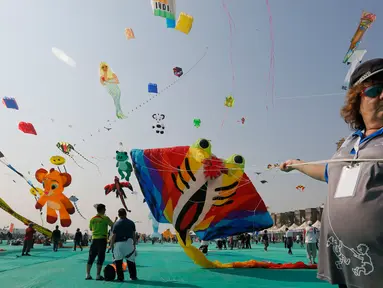 Seorang peserta dari Australia menerbangkan layang-layang saat festival layang-layang internasional di Ahmadabad, India (7/1). Dalam festival ini layang-layang dari berbagai negara menghiasi langit Ahmadabad, India. (AP Photo/Ajit Solanki)