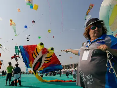 Seorang peserta dari Australia menerbangkan layang-layang saat festival layang-layang internasional di Ahmadabad, India (7/1). Dalam festival ini layang-layang dari berbagai negara menghiasi langit Ahmadabad, India. (AP Photo/Ajit Solanki)