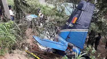 Petugas penyelamat memeriksa puing-puing  pesawat milik Angkatan Udara Sri Lanka yang jatuh di daerah pegunungan penghasil teh di Haputale, Jumat (3/1/2020). Empat orang kru yang berada di pesawat tewas dalam insiden tersebut. (Photo by STR / AFP)
