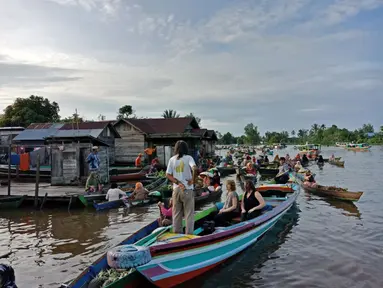 Wisatawan asing sedang menikmati berinteraksi dengan pedagang di Pasar Terapung Lok Baintan, Banjarmasin (Liputan6.com/Pool/Kadek Arini)