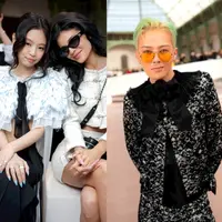 Sebagai ikon mode, Kylie Jenner tampil memukau dalam tweed putih klasik khas Chanel. Jaket cropped yang memperlihatkan bagian perut dipadukan dengan rok mini lipit, menciptakan siluet modern yang edgy. Detail kancing perak pada jaket memberikan sentuhan mewah, sementara aksesori seperti sabuk rantai mutiara dan gelang emas menambah kesan glamor. Sepatu hak slingback dan kacamata cat-eye hitam melengkapi tampilan elegannya.