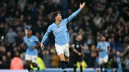 Pemain Manchester City, John Stones, melakukan selebrasi setelah mencetak gol ke gawang Arsenal pada laga Liga Inggris di Stadion Etihad, Minggu (22/09/2024). (AP Photo/Dave Thompson)