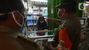 Petugas gabungan melakukan razia pertokoan dan tempat makan di Pasar Pramuka, Jakarta, Kamis (24/9/2020). Upaya mencegah penularan virus corona terus dilakukan dengan merazia penggunaan masker dan tempat usaha makan yang masih melayani makan di tempat. (merdeka.com/Imam Buhori)