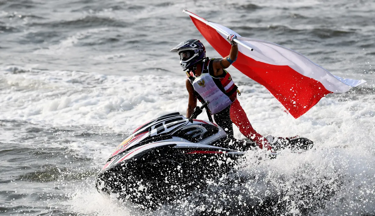 Atlet jetski Indonesia, Aqsa Sutan Aswar memacu jetskinya sambil membawa bendera Merah Putih setelah memperoleh medali emas kelas endurance runabout buka di Asian Games 2018, Jakarta, Minggu (26/8). (ANTARA FOTO/INASGOC/Andry Bey/inp/18)