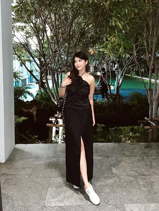 Melihat pesona Mici dalam balutan gaun hitam tanpa lengan. Gaun ini memiliki tali spageti yang melingkari lehernya dan high slit yang memperlihatkan kaki jenjangnya. [Foto: Instagram/parramitha]