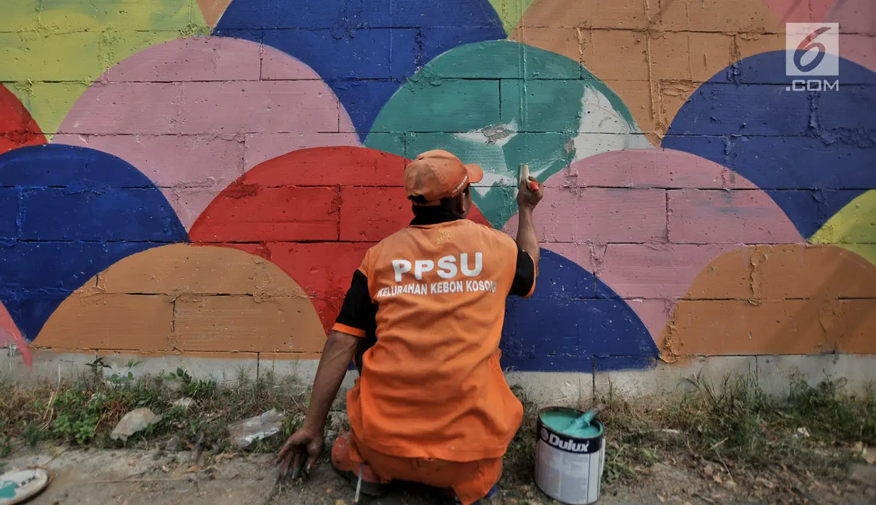 Petugas PPSU mengecat saat pembuatan mural pada tembok yang berada di pinggir Jalan Landasan Pacu, Jakarta, Rabu (11/7). Pengecatan dan pembuatan mural ini dalam rangka mempercantik kawasan serta menyambut Asian Games 2018. (Merdeka.com/Iqbal S. Nugroho)