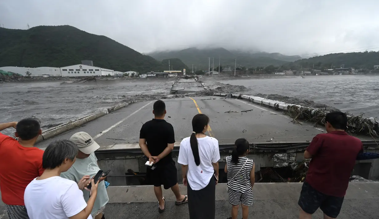 Sedikitnya 11 orang tewas dan 13 hilang setelah hujan lebat melanda Beijing, kata media pemerintah pada 1 Agustus, dalam hujan deras yang merendam jalan dan banjir. lingkungan dengan lumpur. (AFP/Pedro Pardo)